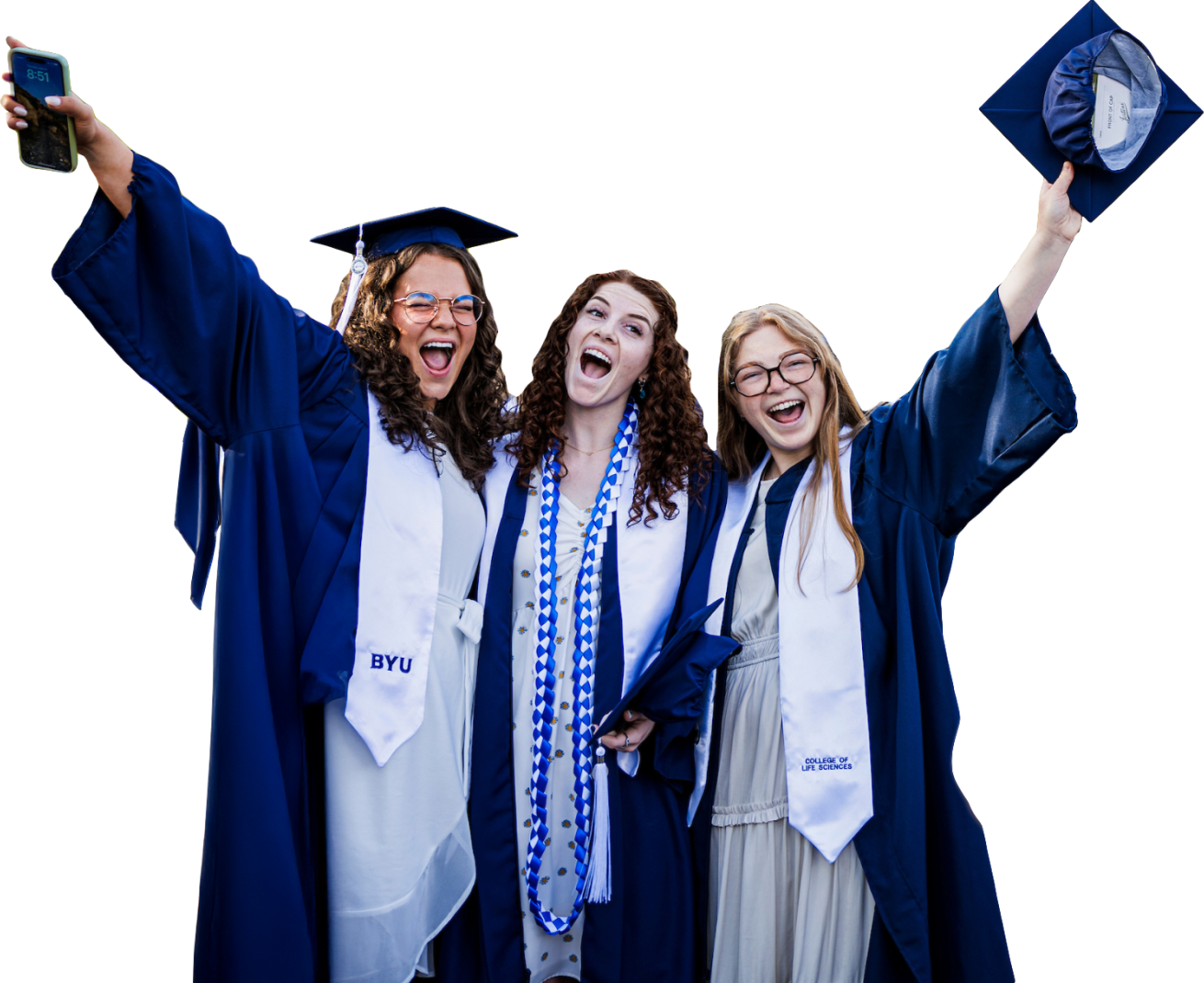 three female students cheering in their graduation gowns